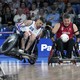Two wheelchair rugby competitors vie for a ball during a match at the Paralympic Games.