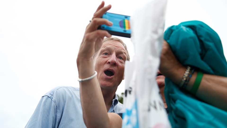 Tom Steyer makes a funny face while taking a selfie with a woman at the Iowa State Fair.