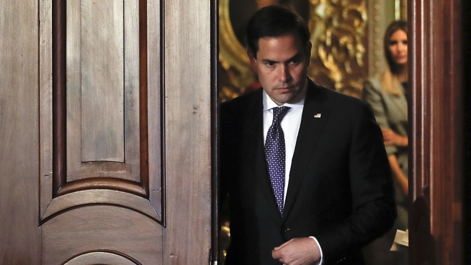 Florida Senator Marco Rubio walks through a doorway.