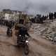 Photo showing Syrian civilians inspecting a destroyed residential building following a 7.8-magnitude earthquake