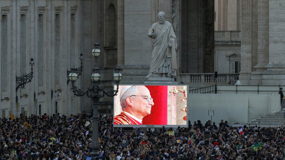 A photo of a crowd watching a screen as the newly elected Pope Leo XIV appears on the balcony of St. Peter's Basilica, at the Vatican