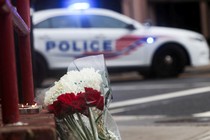 Flowers at a memorial in front of a police car