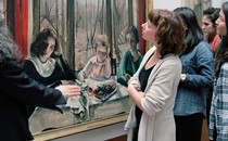 A group of bystanders look at a painting.