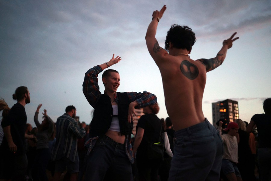 People dance outside at sunset.