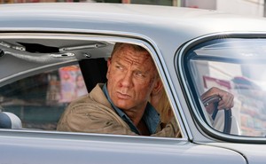 James Bond, played by Daniel Craig, looks out of the window of a car.
