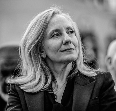 black-and-white photo of woman in suit smiling and looking to her left