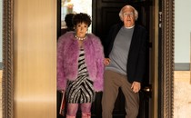 Larry David and Susie Essman stand in a doorway