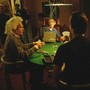 Stephen Hawking and actors dressed as Isaac Newton and Albert Einstein sit at a poker table surrounded by a film crew.
