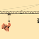 A crane lifts up a teddy bear by its foot.