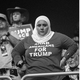 A black-and-white photo of a woman wearing an "Arab Americans for Trump" shirt