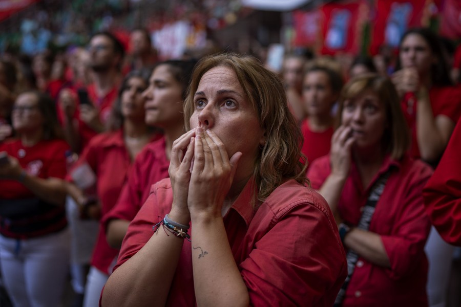 People stand together, looking up, making worried faces.