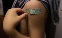 A kid's shoulder, with a Band-Aid, after a shot
