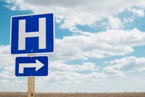 Hospital road sign in an open field.