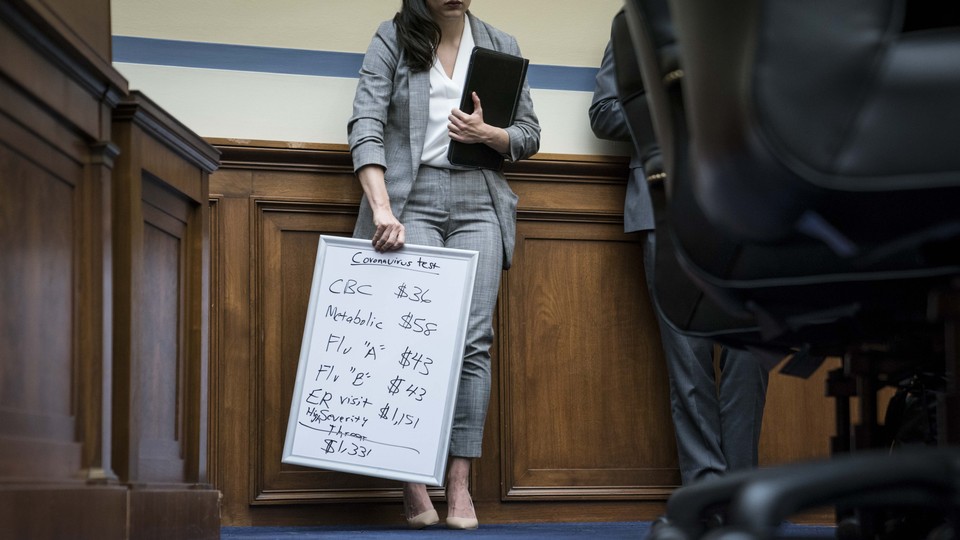 A staffer for Representative Katie Porter holds a board outlining the cost of coronavirus testing.