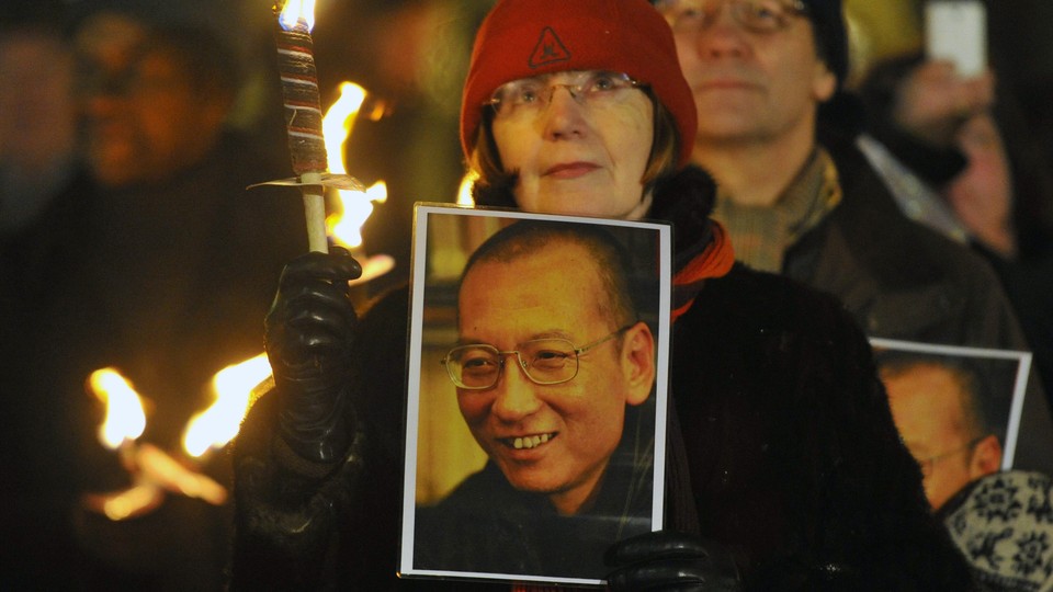 A woman holds a photograph of Xiaobo during a procession in Oslo following the 2010 Nobel Peace Prize ceremony.