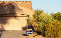 A Biden sign outside of a house with an arid, western-looking yard