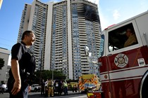 A police officer directs a fire truck at the Marco Polo apartment building after a fire broke out in it in Honolulu, Hawaii.