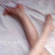 An image of legs on bedsheets
