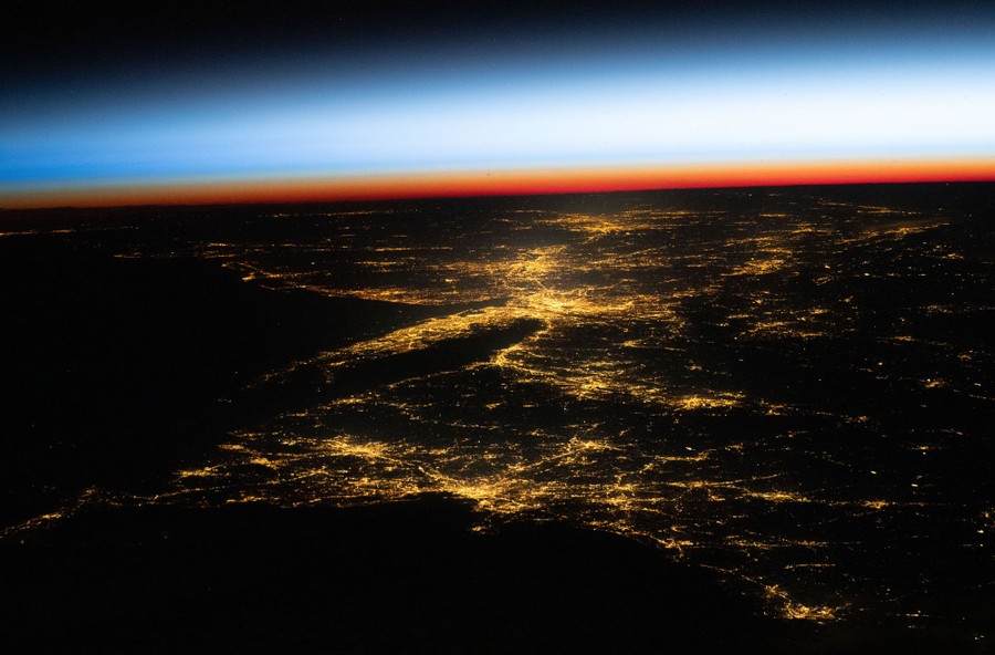 A night view of the lights of many cities, including Boston and New York City