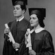 A man and a woman hold college diplomas