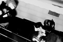 Two boxers in headgear and gloves face off