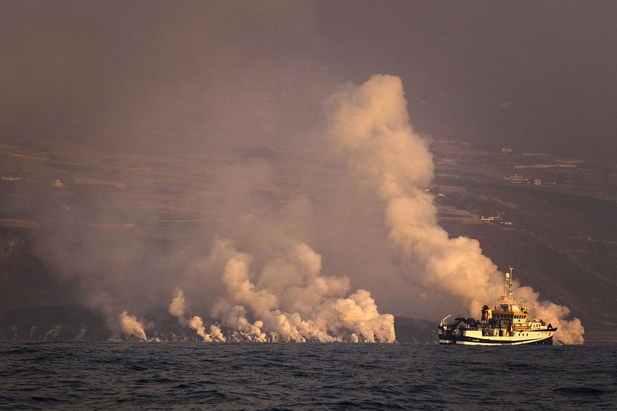 Clouds of gas are seen as lava from a volcano enters the sea.