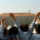 A photo of schoolgirls in the West Bank waving at Israelis who are on the other side of a wall