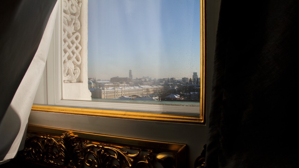 Moscow is seen through the window of a darkened hotel room.