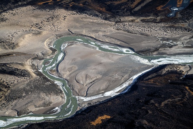 aerial photo of river of water that separates and rejoins in glacial valley
