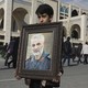 A boy carries a portrait of the Iranian Revolutionary Guard Corps general Qassem Soleimani.