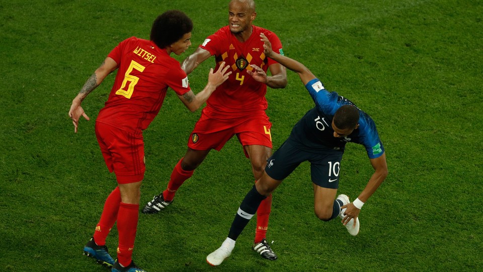 Three soccer players shoving each other