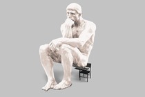 illustration of oversized white "Thinker" sculpture resting on small black schooldesk chair on gray background
