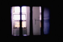Photo showing an open window in a prison captured from behind bars