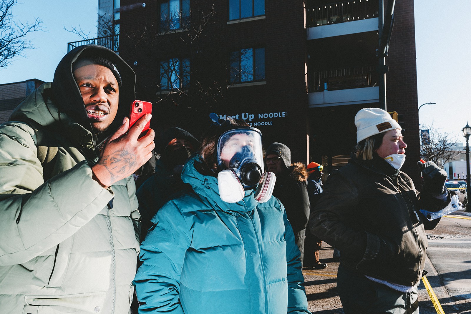 The people are seen in front of police tape in the street