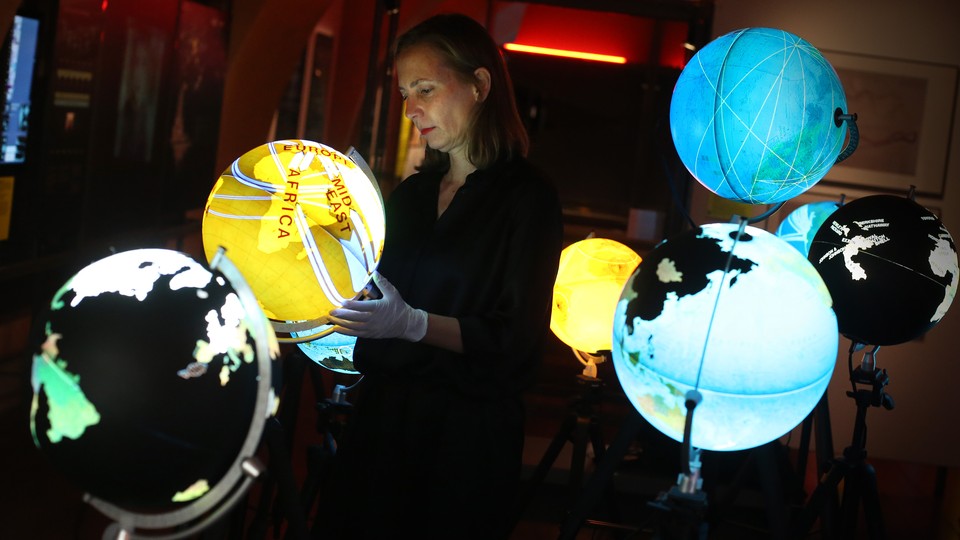 Curator Olga Subiros checks Ingo Gunther’s Worldprocessor globes visualizing world data at the Big Bang Data exhibition at Somerset House on December 2, 2015, in London, England.