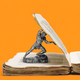 A miniature statue of a muscular man standing on an old tattered book, lifting a page as if struggling, with an orange backdrop