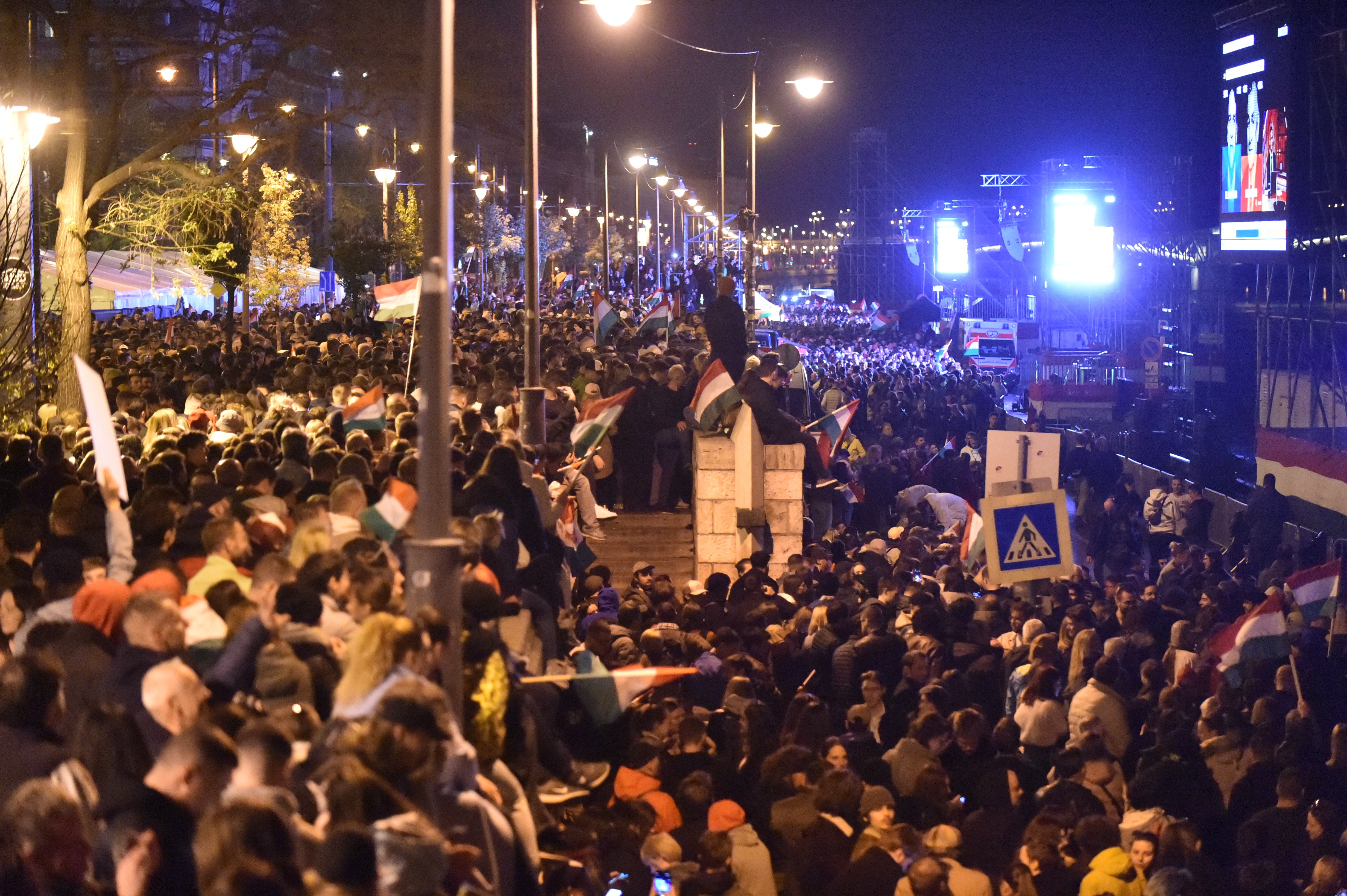 A large crowd gathers to listen to a political victory speech.