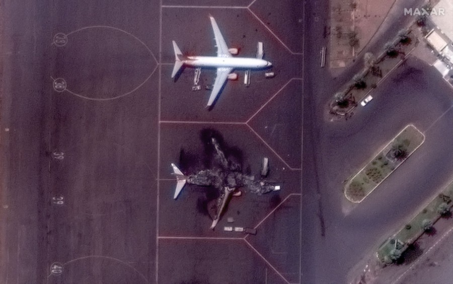 Satellite view of an airport parking area with two airplanes—one completely destroyed
