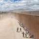 Photo of asylum seekers waiting along a border fence to be processed, March 2024, El Paso, Texas