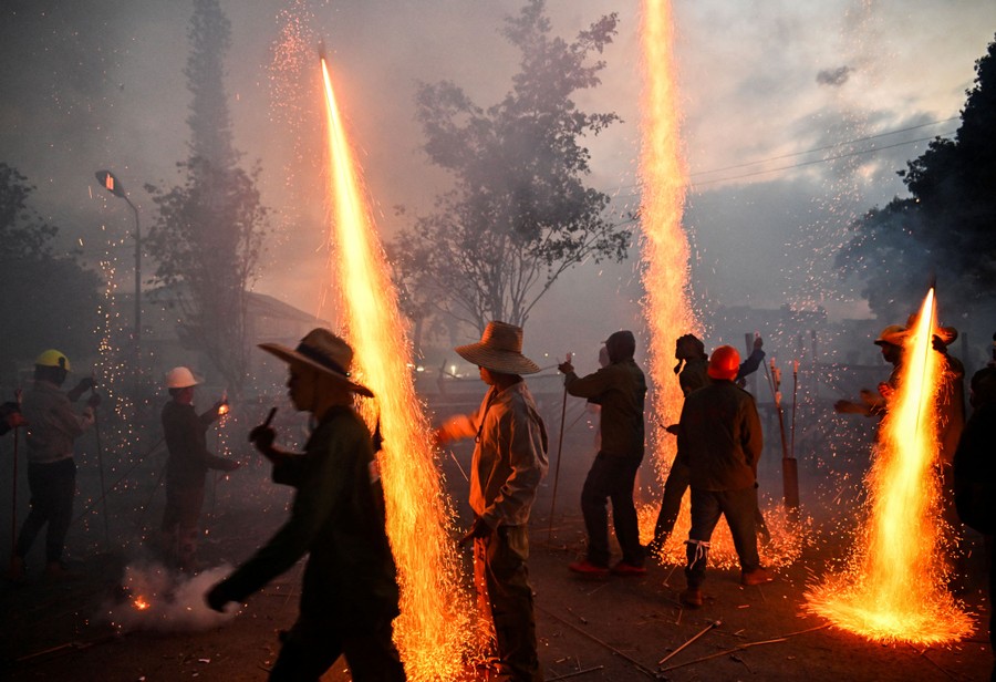 People gather during a festival, launching multiple bottle rockets.