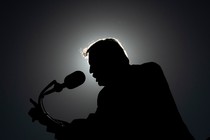 Silhouette of Donald Trump speaking into a microphone