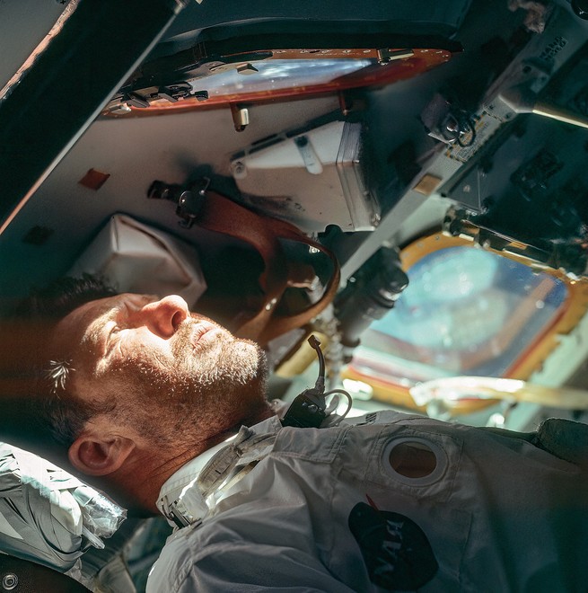 photo of astronaut inside cockpit looking out window with bright sunlight on his face