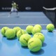Eleven tennis balls near a tennis court