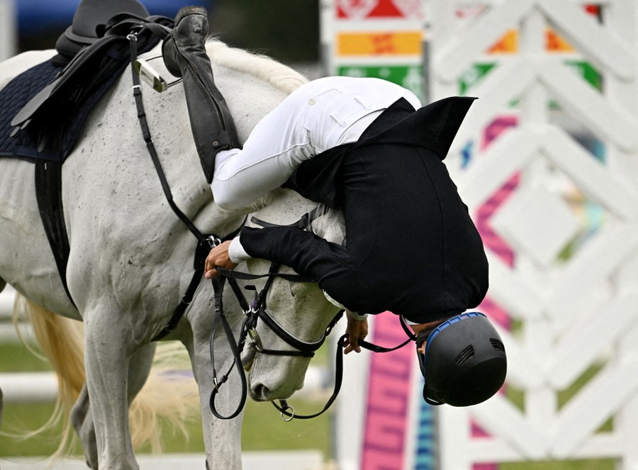 A rider falls over their horse's head during a relay race.