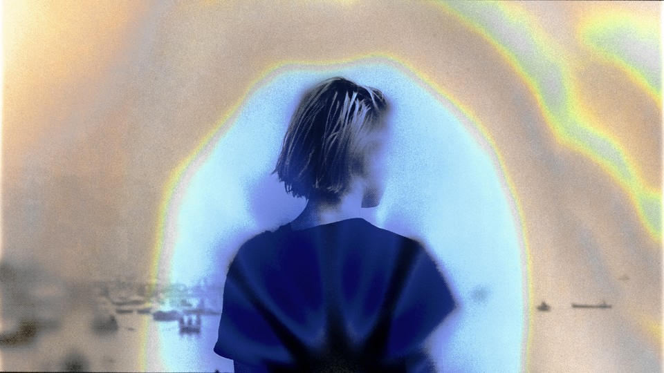 Image of a young woman from behind, surrounded by a hazy, colorful aura