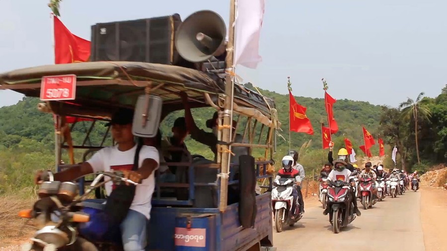 Protesters ride together on motorcycles on a rural road.
