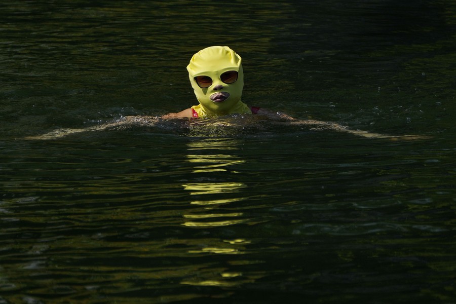 A woman wearing sun-protection headgear swims.