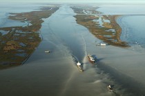 Two large boats travel on a drought-stricken Mississippi River