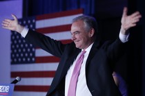 Tim Kaine raises his arms during an election party