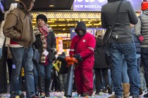 A man cleans up confetti while surrounded by tourists in Times Square in New York.